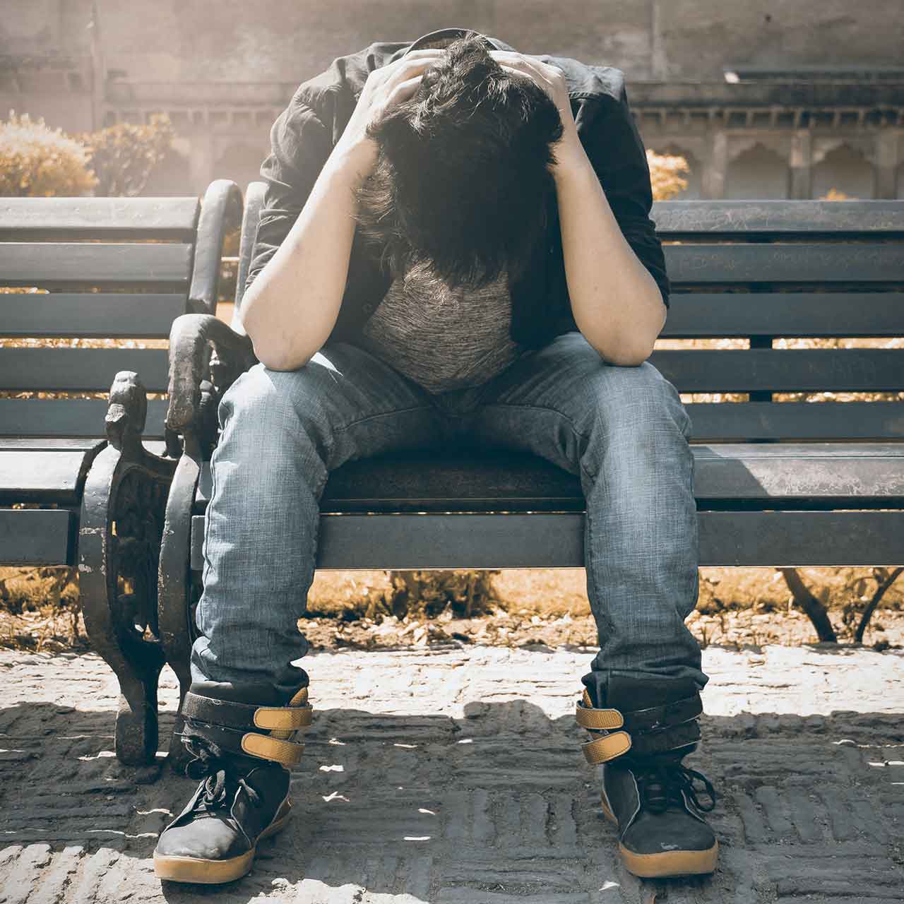 Photo of a sad man sitting on a bench